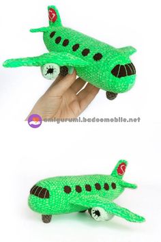 a hand holding a green stuffed toy airplane in it's right side and the other side