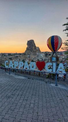 a sign that says cappad cia with hot air balloons in the sky above it