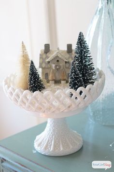 a cake plate with trees on it and a house in the background