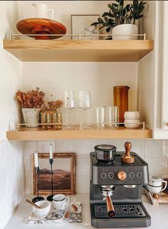 an espresso machine sitting on top of a counter next to some plates and cups