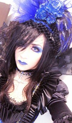 a close up of a doll with blue makeup