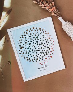 a card with leaves on it sitting next to some dried flowers and a crochet doily