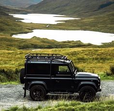 a black jeep parked on top of a gravel road