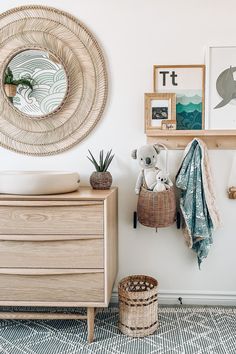 a baby's room with a dresser, mirror and pictures on the wall