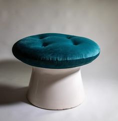 a white pedestal with a green cushion on it