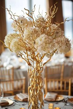 a tall vase filled with white flowers on top of a table