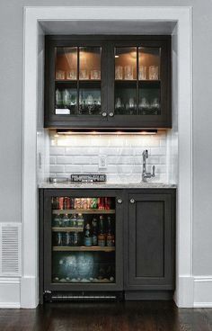 a kitchen with black cabinets and white walls