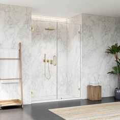 a bathroom with marbled walls and flooring next to a plant in a vase