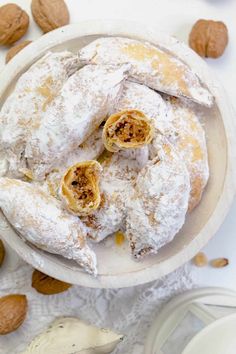 almonds and powdered sugar on top of a plate with pastries in the middle