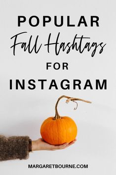 a hand holding a pumpkin with the text popular fall hashings for instagrams