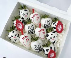 a box filled with lots of white chocolate covered in red and black frosted decorations