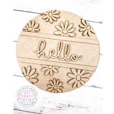 a wooden plaque with the word hello on it and daisies in front of a white background