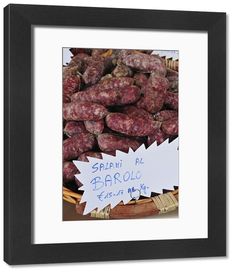 some sausages are on display in a black frame with a white sign that says sani de barolo