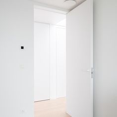 an empty room with white walls and wooden floors