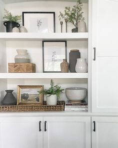 white shelves with vases and pictures on them