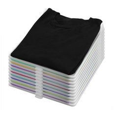 a stack of black t - shirts sitting on top of each other in front of a white background