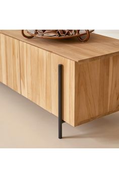 a close up of a wooden cabinet with a bowl on it's sideboard