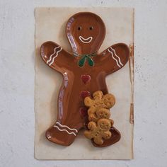 a ceramic ginger man holding two teddy bears on a tile wall hanging ornament