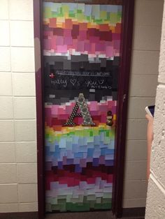 a door decorated with colorful paper squares and writing on the front wall is shown in this hallway