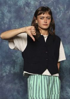 a woman is posing for a photo with her hand on her hip and pointing at the camera