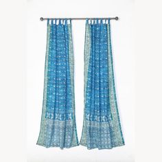 two blue curtains hanging on a metal rod