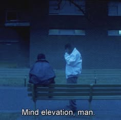 two people sitting on a bench in front of a building with the words mind elevation, man