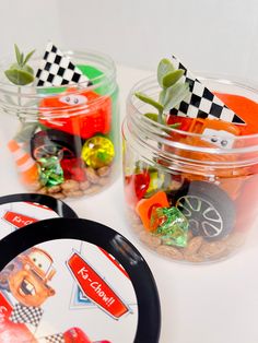 three jars filled with candy and candies on top of a white table next to each other