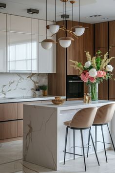 a kitchen with marble counter tops and bar stools next to an island topped with flowers