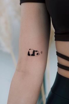 a woman's arm with a panda bear tattoo on the left side of her arm