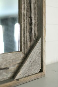 an old wooden frame with a mirror behind it