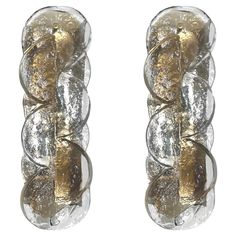 two glass wall sconces with gold and silver accents on each side, one in the