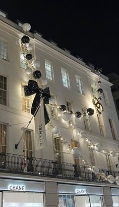 a chanel store front at night with lights on the windows and decorations hanging from the building