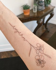 a woman's arm with a tattoo on it that reads, love and flowers