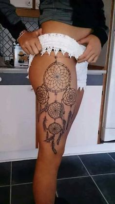 a woman's leg with a tattoo on it and a dream catcher in the middle