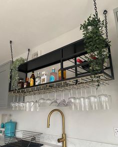 a kitchen sink filled with lots of wine glasses and bottles on top of a shelf