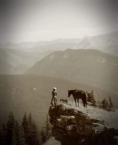 a man standing on top of a cliff next to a horse