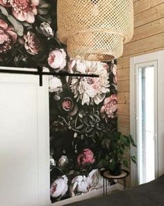 a bedroom with flowers on the wall and a basket hanging from the ceiling above it