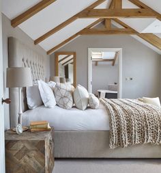 a large bed sitting under a wooden beam in a bedroom