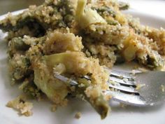 a white plate topped with broccoli covered in cheese and bread crumbs