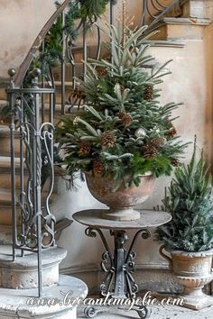 a christmas tree sitting on top of a table next to a banister and stairs