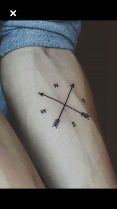 a woman's arm with an arrow tattoo on it