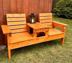 a wooden bench sitting next to a wall with a lantern on it's side