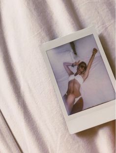 a polaroid photo of a woman laying in bed