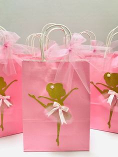 three pink bags with gold ballet designs on them