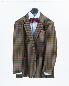 SIZE: US 44, EU 54.  COLORS: khaki green, brown, navy blue, ox blood-red, light blue, teal blue, beige.  MATERIAL: 100% wool.  FEATURES: this highest quality khaki green men's Daks blazer is entirely made in England from the iconic plaid check pattern. The jacket is crafted from wool material, has 2 leather button front fastening and is double vented in back. This British heritage brand blazer is skillfully constructed with attention to detail featuring suede leather reinforced buttonholes and e Brown Wool Flat Front Suit, Casual Green Wool Blazer, Brown Flat Front Suit For Fall, Brown Flat Front Suits For Fall, Classic Brown Suits For Fall, Classic Wool Outerwear With Custom Fit, Custom Fit Wool Outerwear With Welt Pockets, Casual Brown Tweed Jacket With Lapel Collar, Casual Brown Single-breasted Tweed Jacket