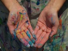 two hands that are covered in colored paint