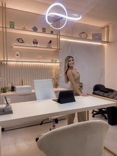 a woman standing in front of a white desk