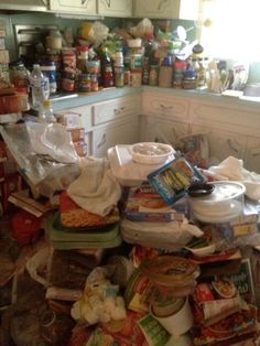 a kitchen filled with lots of clutter and food in containers on top of the floor