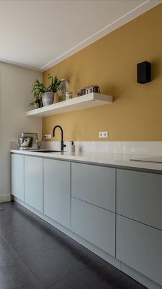 a kitchen with yellow walls and white cabinets