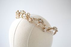 Lavishly designed with ethereal elements, our Antique gold crystal bridal tiara is sure to turn heads as you walk down the aisle. - Handcrafted with Premium European crystals and pearls- Each stone is set by hand in my studio- Golden shadow, ivory cream, white opal, clear stones, and crystal pearls- Antique gold finish- Tiara measures 15.5 inches x 1.25 inches- Handcrafted in the US.- Nickel free and hypoallergenic- PLEASE ALLOW APPORX 6-8 WEEKS FOR COMPLETIONThis is an original design by © Trea Simple Design Clothes, Wedding Jewelry Simple, Crystal Bridal Tiaras, Golden Shadow, Walk Down The Aisle, Queen Aesthetic, Pearl Tiara, Headpiece Jewelry, Rose Gold Crystal